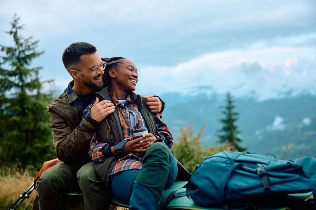 young couple cuddling looking over vista in cold weather