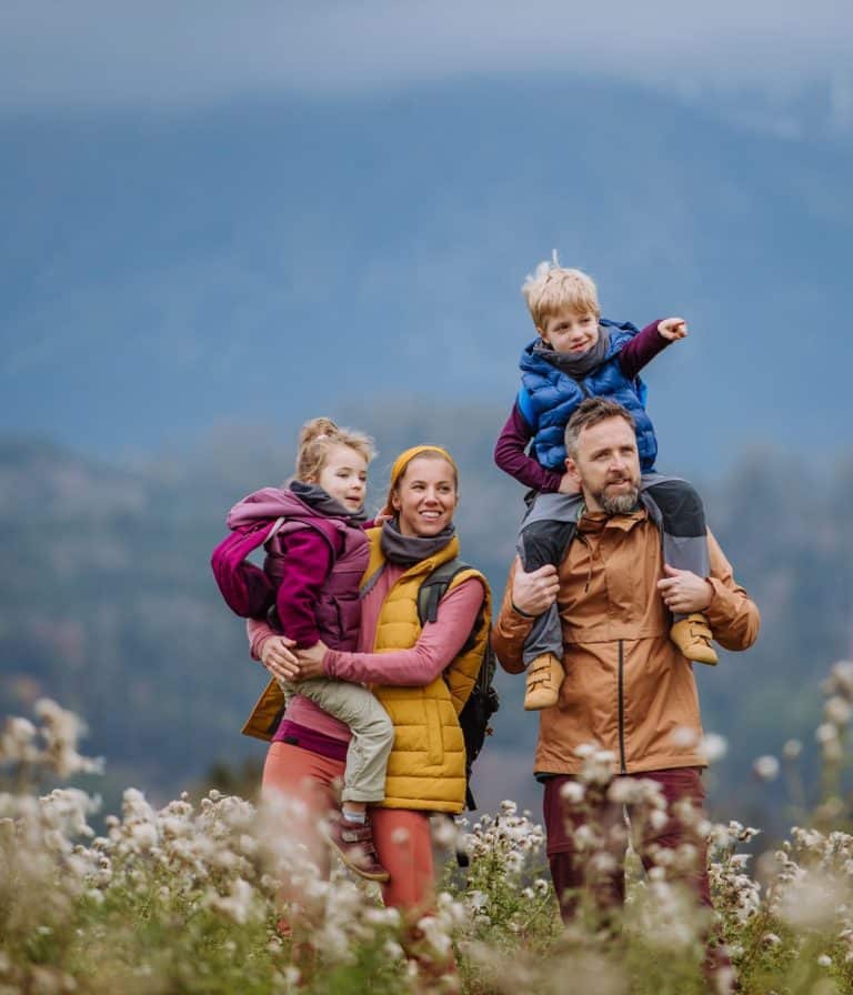 happy family of four hiking in spring