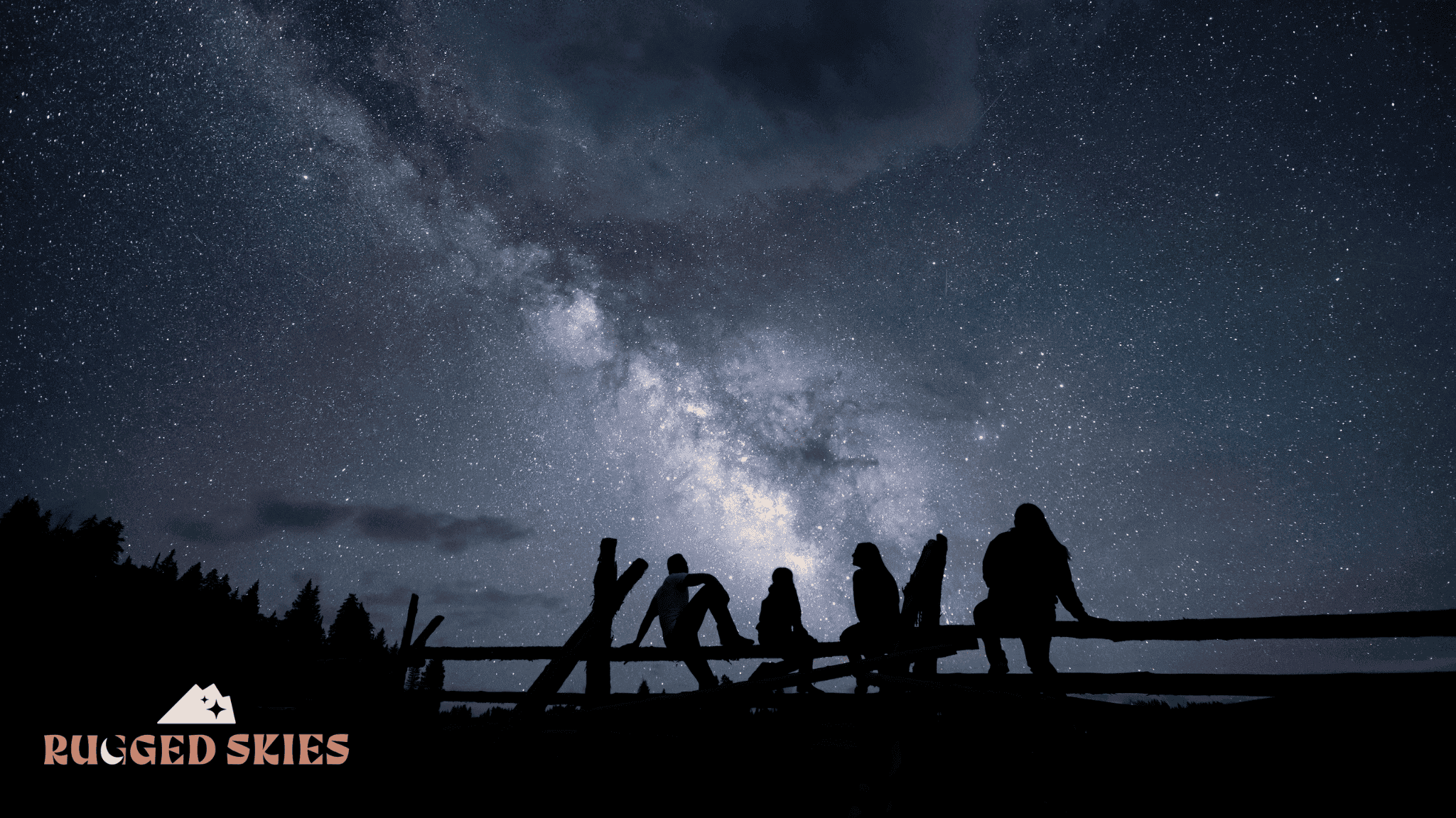 Group of stargazers sitting on fence staring at blue and white milky way galaxy